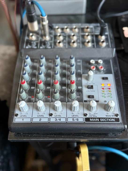 Audio mixing console with multiple knobs and input/output connections.